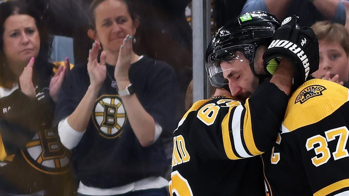 Patrice Bergeron hugs Brad Marchand before exiting the ice after Florida Panthers defeated the Bruins 4-3 in overtime of Game Seven of the First Round of the 2023 Stanley Cup Playoffs.