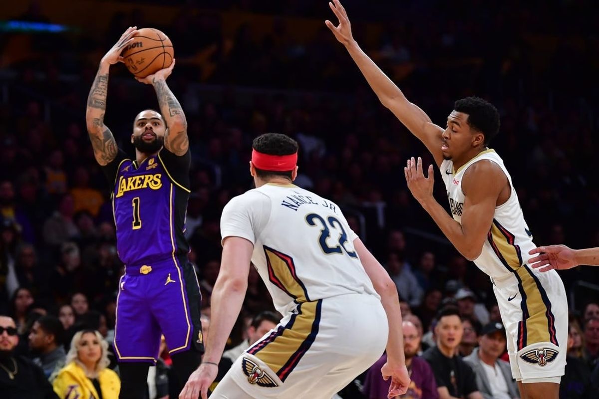 Feb 9, 2024; Los Angeles, California, USA; Los Angeles Lakers guard D'Angelo Russell (1) shoots against New Orleans Pelicans guard CJ McCollum (3) and forward Larry Nance Jr. (22) during the first half at Crypto.com Arena.