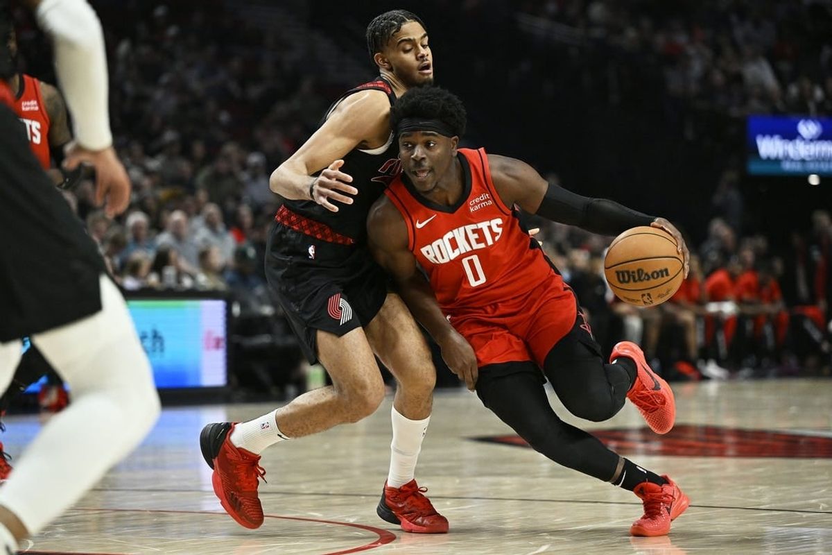 Apr 12, 2024; Portland, Oregon, USA; Houston Rockets guard Aaron Holiday (0) drives to the basket during the first half against Portland Trail Blazers guard Rayan Rupert (72) at Moda Center.