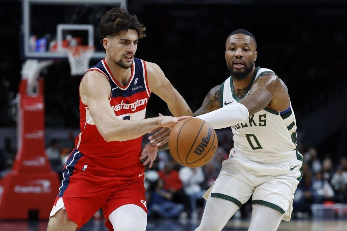 Nov 20, 2023; Washington, District of Columbia, USA; Washington Wizards forward Deni Avdija (8) drives to the basket as Milwaukee Bucks guard Damian Lillard (0) defends in the first quarter at Capital One Arena.