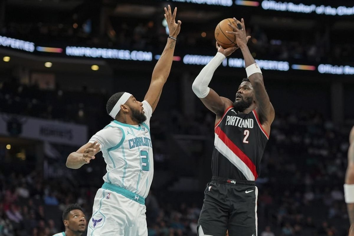 Apr 3, 2024; Charlotte, North Carolina, USA; Portland Trail Blazers center Deandre Ayton (2) shoots a long range jumper against Charlotte Hornets Marques Bolden (3) during the second quarter at Spectrum Center.