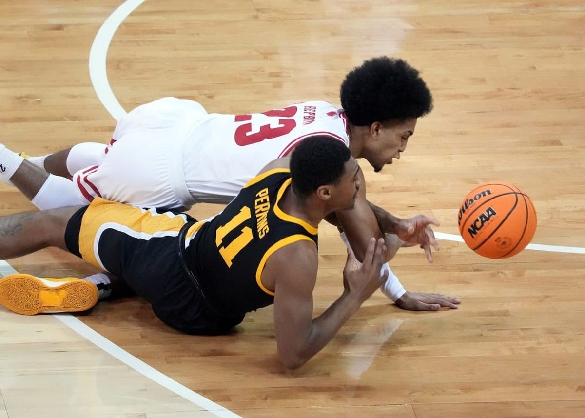 Jan 2, 2024; Madison, Wisconsin, USA;  Wisconsin Badgers guard Chucky Hepburn (23) and Iowa Hawkeyes guard Tony Perkins (11) go after a loose ball during the first half at the Kohl Center.