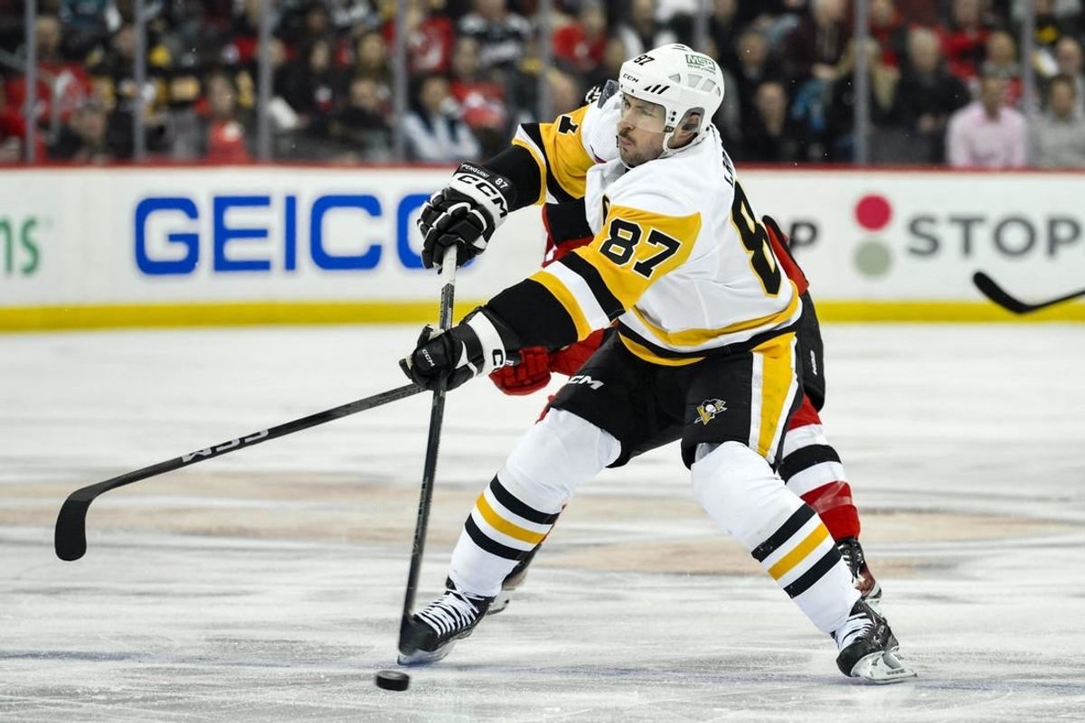 Apr 2, 2024; Newark, New Jersey, USA; Pittsburgh Penguins center Sidney Crosby (87) takes a shot as New Jersey Devils defenseman Brendan Smith (2) defends during the third period at Prudential Center.