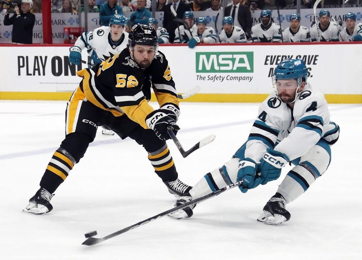 Mar 14, 2024; Pittsburgh, Pennsylvania, USA; San Jose Sharks defenseman Kyle Burroughs (4) defends Pittsburgh Penguins right wing Emil Bemstrom (52) during the first period at PPG Paints Arena.