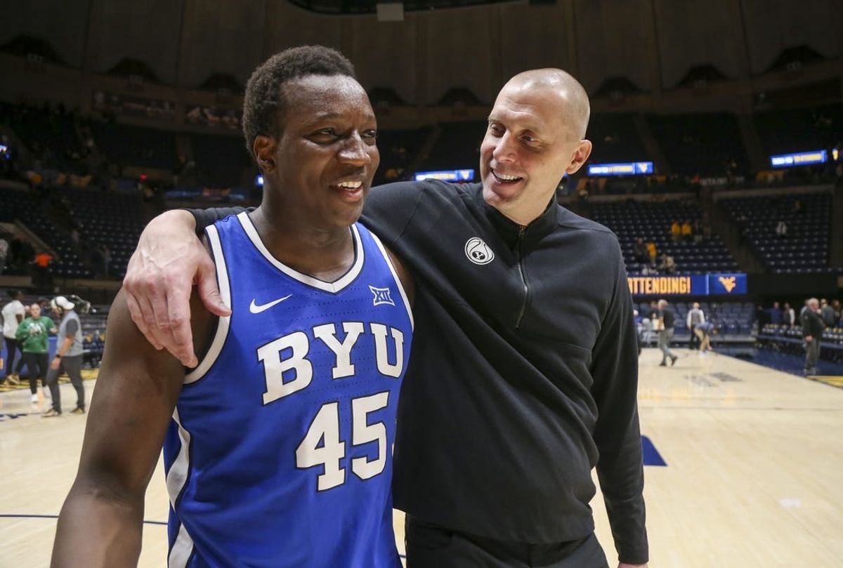 Feb 3, 2024; Morgantown, West Virginia, USA; Brigham Young Cougars head coach Mark Pope celebrates with Brigham Young Cougars forward Fousseyni Traore (45) after defeating the West Virginia Mountaineers at WVU Coliseum.