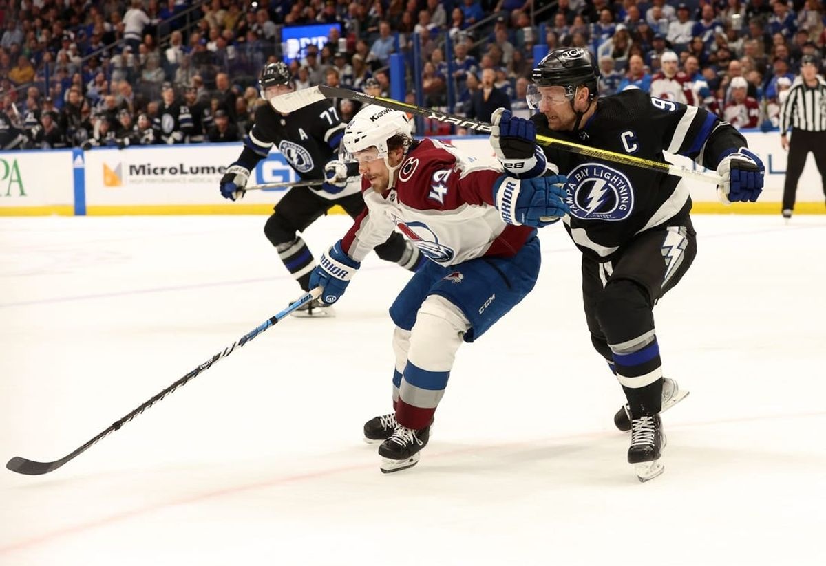 Feb 15, 2024; Tampa, Florida, USA; Tampa Bay Lightning center Steven Stamkos (91) and Colorado Avalanche defenseman Samuel Girard (49) skate after the puck during the first period at Amalie Arena.