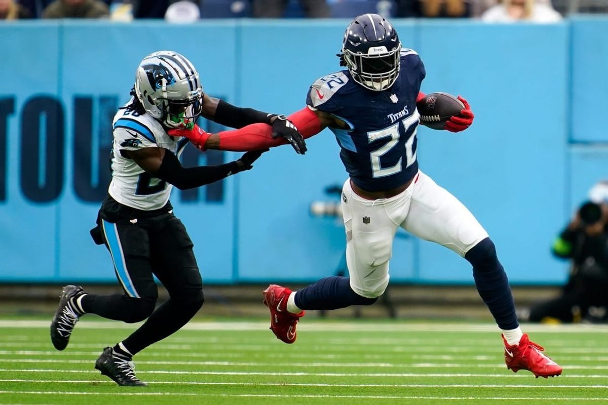 Tennessee Titans running back Derrick Henry (22) tries to evade Carolina Panthers cornerback David Long Jr. (20) during the third quarter at Nissan Stadium in Nashville, Tenn., Sunday, Nov. 26, 2023.