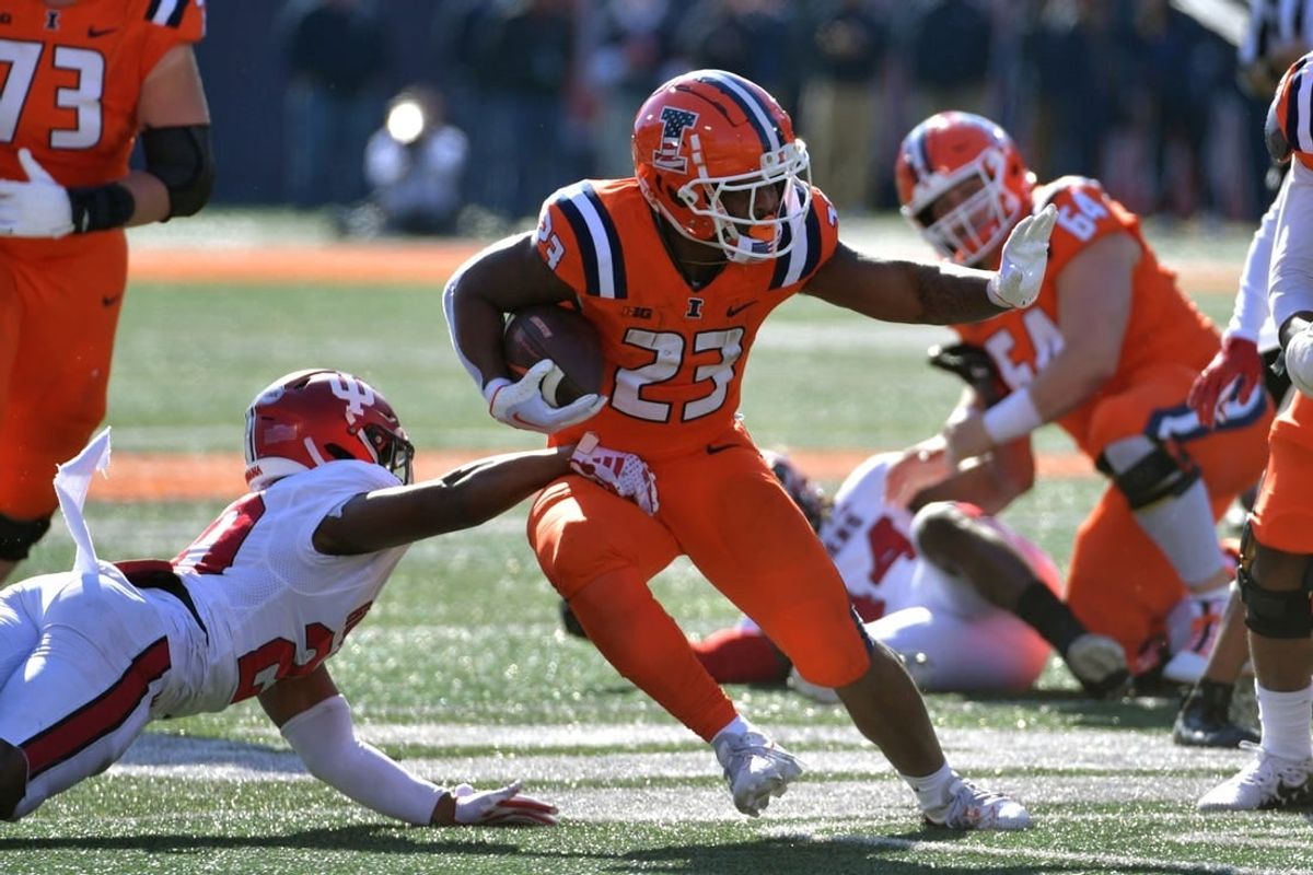 Nov 11, 2023; Champaign, Illinois, USA;  Illinois Fighting Illini running back Reggie Love III (23) eludes the tackle of Indiana Hoosiers defensive back Louis Moore (20) during the first half at Memorial Stadium.