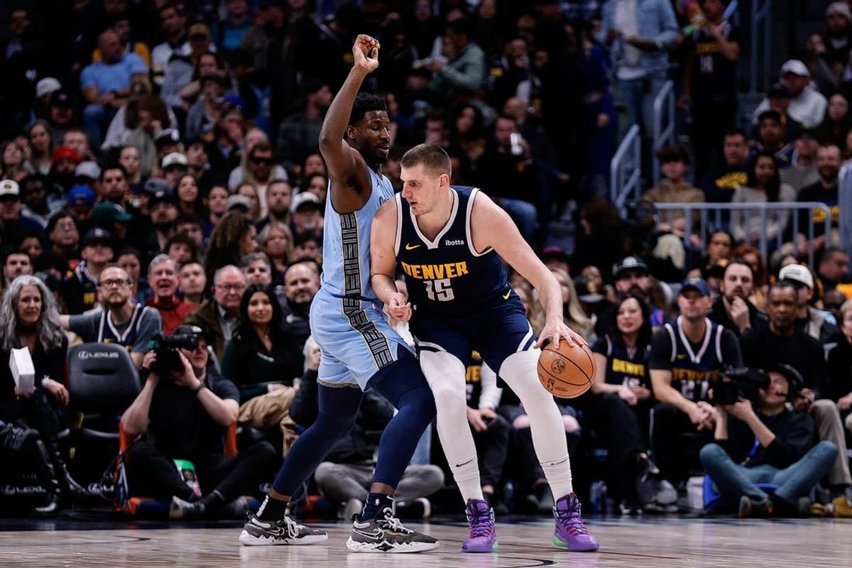 Mar 25, 2024; Denver, Colorado, USA; Denver Nuggets center Nikola Jokic (15) controls the ball against Memphis Grizzlies forward Jaren Jackson Jr. (13) in the second quarter at Ball Arena.