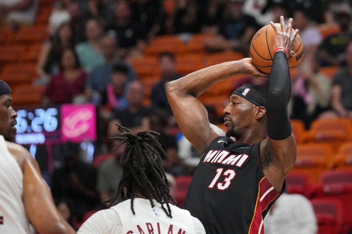 Mar 24, 2024; Miami, Florida, USA;  Miami Heat center Bam Adebayo (13) looks to pass the ball against the Cleveland Cavaliers defense during the first half at Kaseya Center.