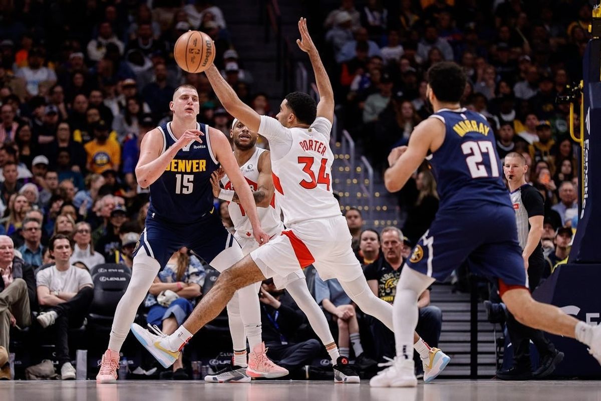 Mar 11, 2024; Denver, Colorado, USA; Denver Nuggets center Nikola Jokic (15) passes the ball to guard Jamal Murray (27) as Toronto Raptors forward Bruce Brown (11) and center Jontay Porter (34) defend in the second quarter at Ball Arena.