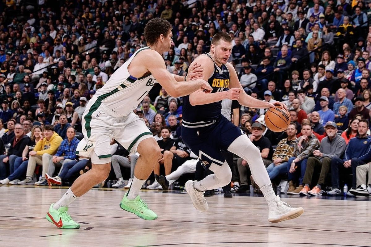 Jan 29, 2024; Denver, Colorado, USA; Denver Nuggets center Nikola Jokic (15) controls the ball against Milwaukee Bucks center Brook Lopez (11) in the fourth quarter at Ball Arena.