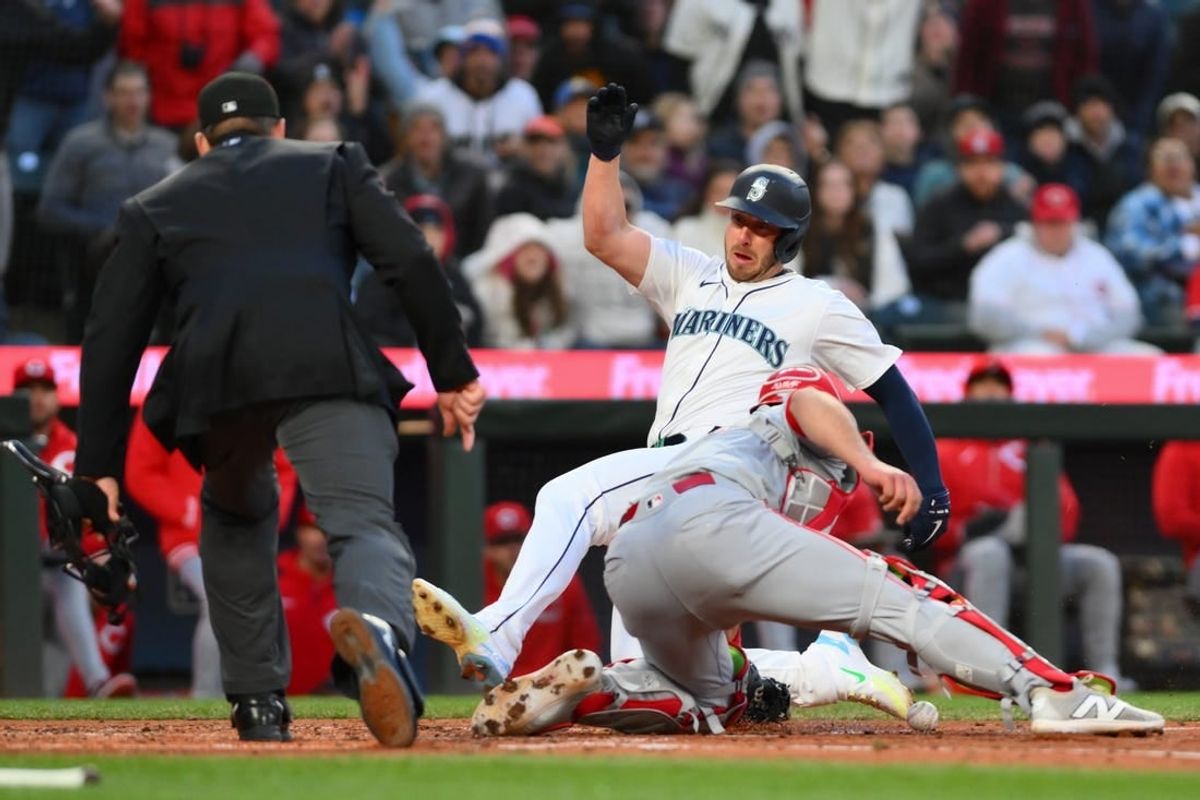 Apr 16, 2024; Seattle, Washington, USA; Seattle Mariners designated hitter Mitch Garver (18) scores a run past Cincinnati Reds catcher Luke Maile (22) during the fourth inning at T-Mobile Park.