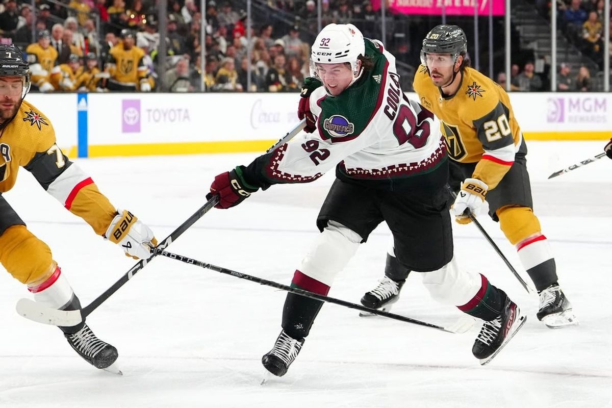 Nov 25, 2023; Las Vegas, Nevada, USA; Arizona Coyotes center Logan Cooley (92) shoots the puck against the Vegas Golden Knights during the second period at T-Mobile Arena.