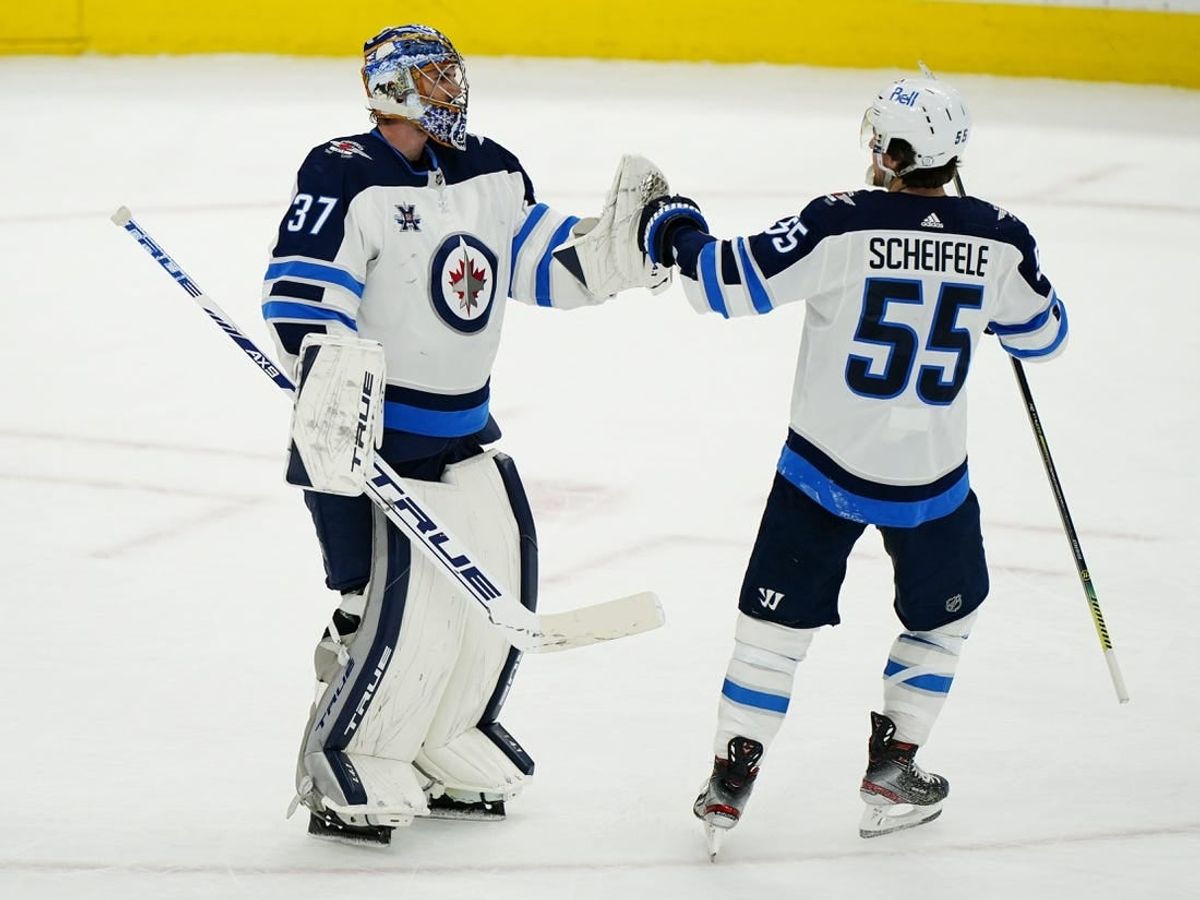 Apr 15, 2021; Toronto, Ontario, CAN; Winnipeg Jets forward Mark Scheifele (55) congratulates goaltender Connor Hellebuyck (37) on a win over the Toronto Maple Leafs during the third period at Scotiabank Arena.