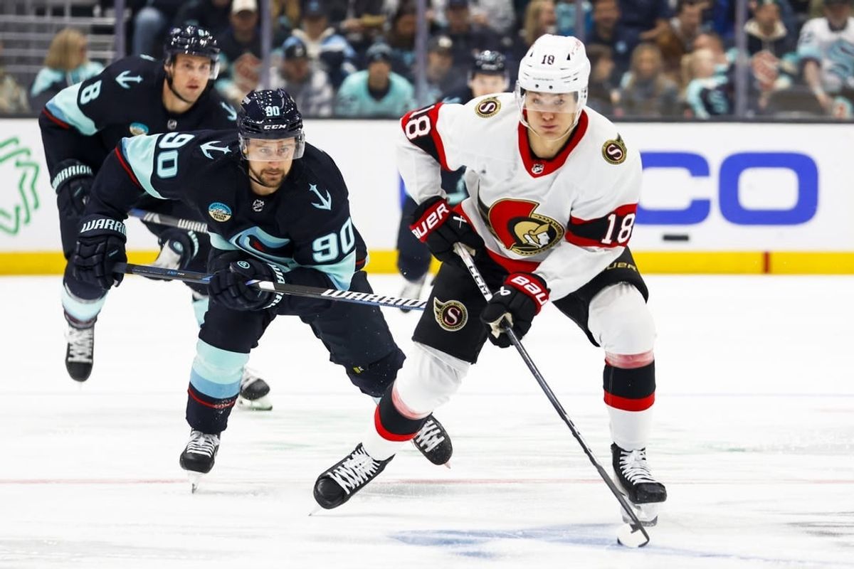 Jan 4, 2024; Seattle, Washington, USA; Ottawa Senators center Tim Stutzle (18) skates with the puck ahead of Seattle Kraken left wing Tomas Tatar (90) during the first period at Climate Pledge Arena.