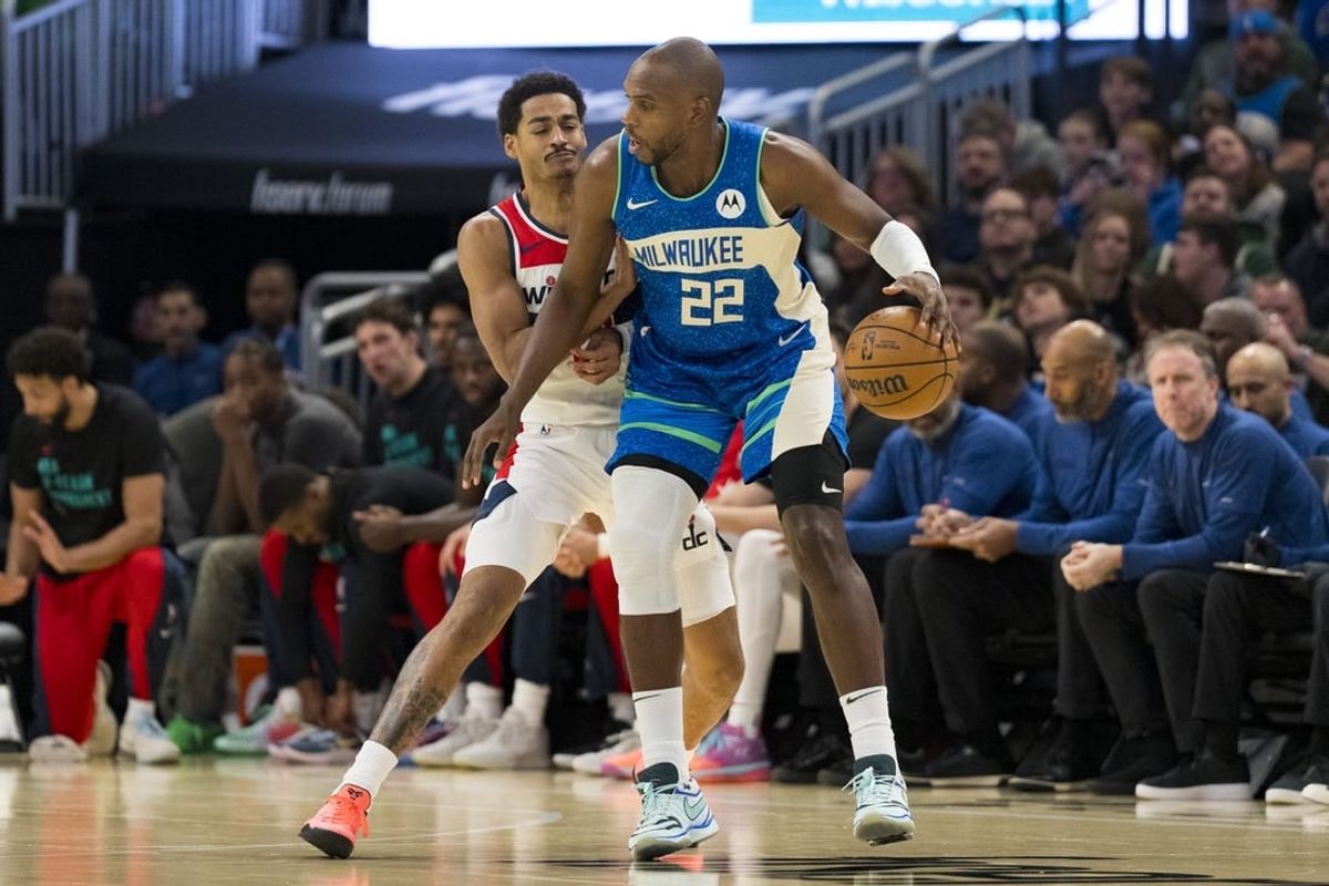 Nov 24, 2023; Milwaukee, Wisconsin, USA;  Milwaukee Bucks forward Khris Middleton (22) dribbles the ball as Washington Wizards guard Jordan Poole (13) defends during the first quarter at Fiserv Forum.