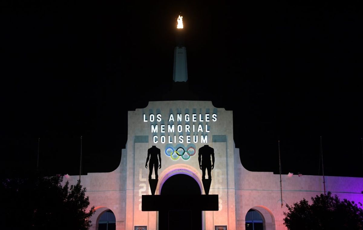Sep 13, 2017; Los Angeles, CA, USA; General overall view of the Los Angeles Memorial Coliseum and Olympic torch illuminated in the colors of the LA2028 logo to commemorate the awarding of the 2028 Olympics and Paralympics to Los Angeles. Mandatory Credit: Kirby Lee-Imagn Images