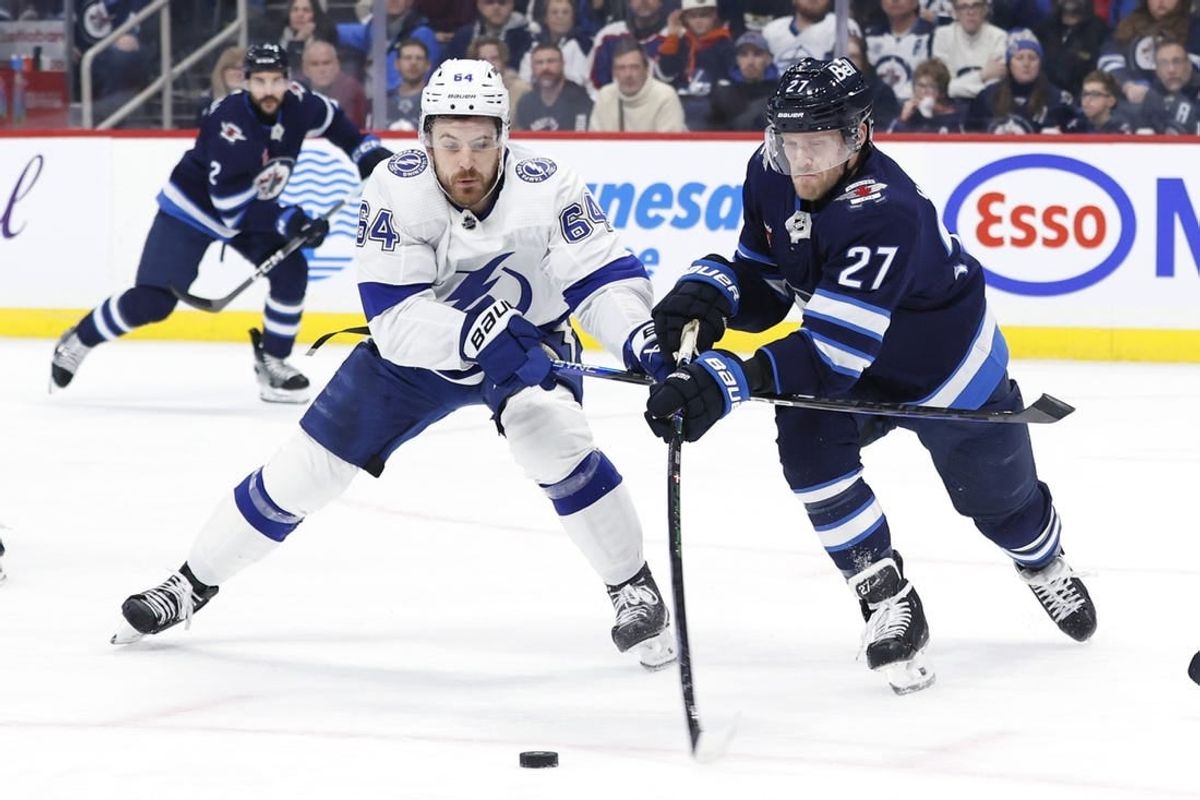 Jan 2, 2024; Winnipeg, Manitoba, CAN; Winnipeg Jets left wing Nikolaj Ehlers (27) is stick checked by Tampa Bay Lightning center Tyler Motte (64) in the first period at Canada Life Centre.