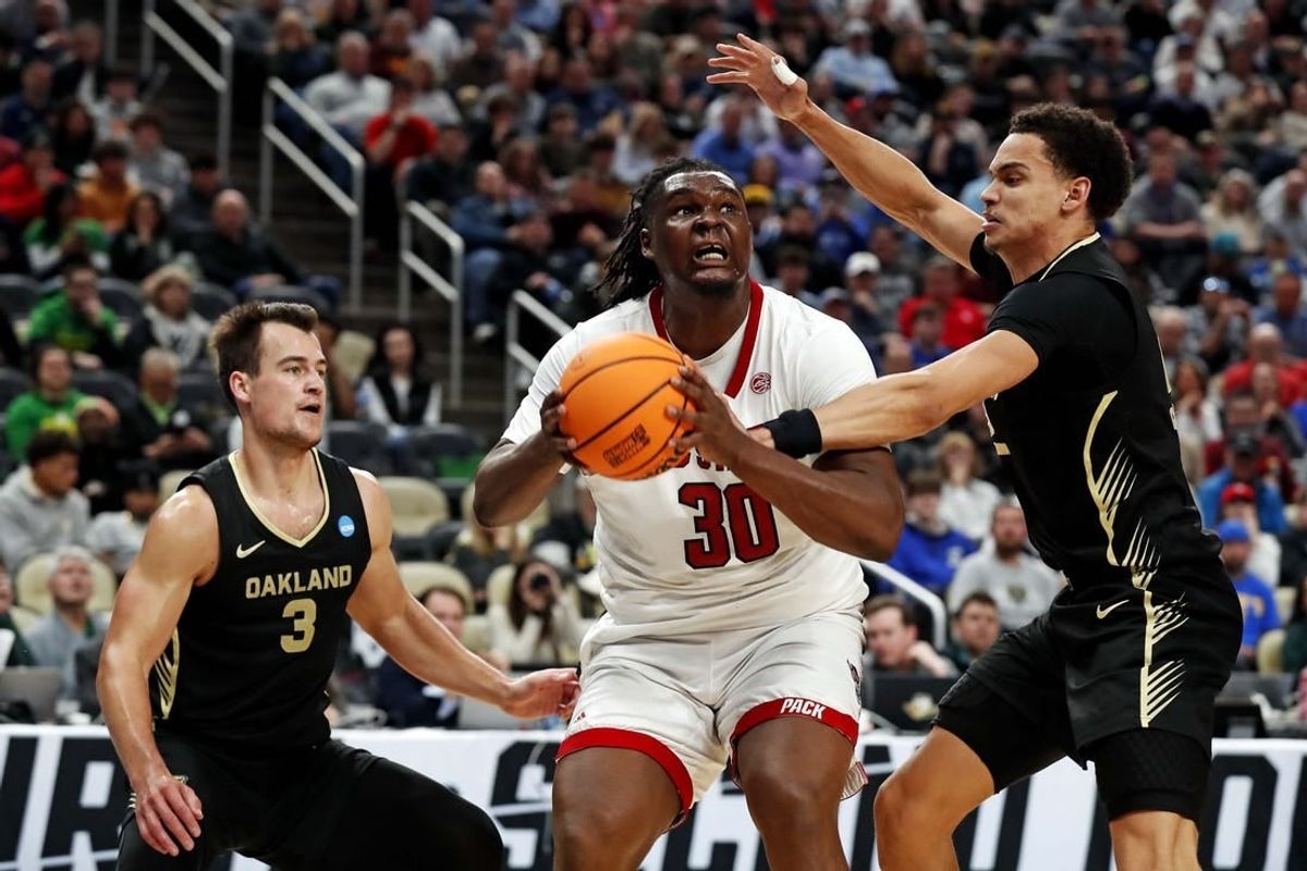 Mar 23, 2024; Pittsburgh, PA, USA; North Carolina State Wolfpack forward DJ Burns Jr. (30) drives to the basket against Oakland Golden Grizzlies forward Chris Conway (2) and guard Jack Gohlke (3) during the second half in the second round of the 2024 NCAA Tournament at PPG Paints Arena.