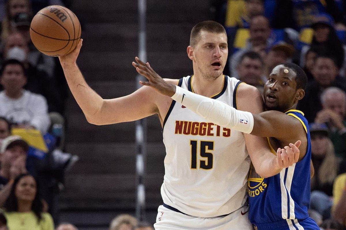 Feb 25, 2024; San Francisco, California, USA; Golden State Warriors forward Jonathan Kuminga (right) harasses Denver Nuggets center Nikola Jokic (15) during the first quarter at Chase Center.