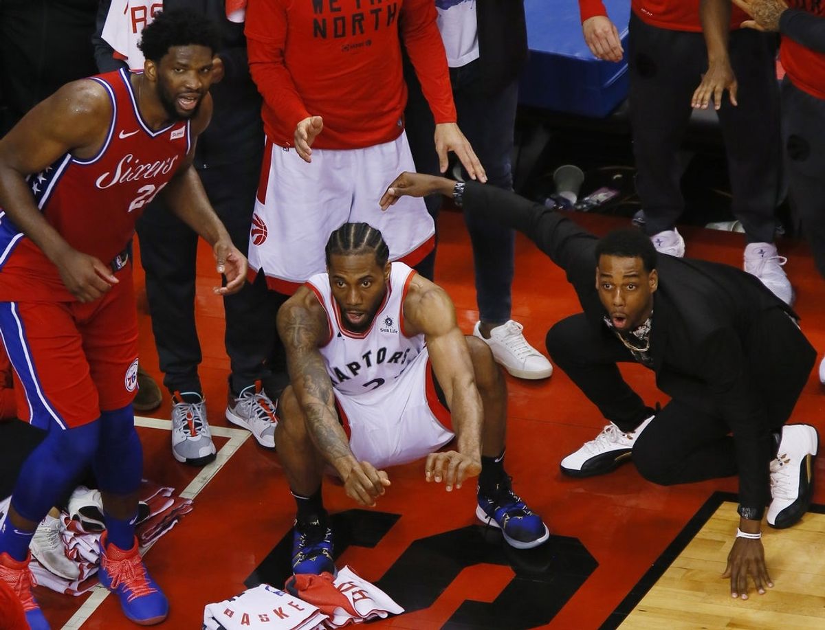 12 de maio de 2019; Toronto, Ontário, CAN; O pivô do Philadelphia 76ers, Joel Embiid (21), e o atacante do Toronto Raptors, Kawhi Leonard (2), aguardam a cesta da vitória de Leonard durante o sétimo jogo da segunda rodada dos Playoffs da NBA de 2019, na Scotiabank Arena. Toronto derrotou Filadélfia. Crédito obrigatório: John E. Sokolowski-Imagn Images