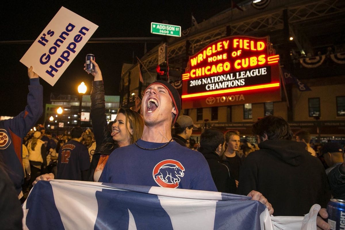A Chicago Cubs fan hold a \"W\" flag as he celebrates outside  Wrigley Field after the Cubs won the National League pennant in 2016.

Cubs fans