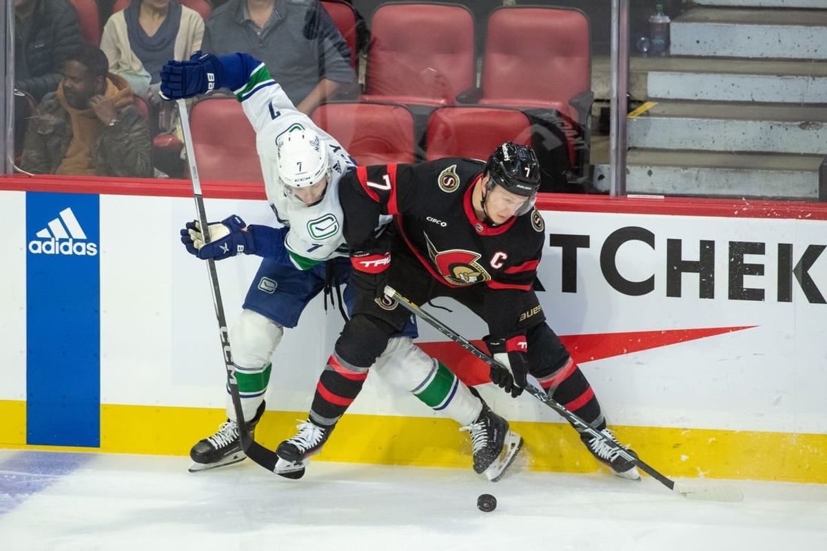 Nov 9, 2023; Ottawa, Ontario, CAN; Vancouver Canucks defenseman Carson Soucy (7) and Ottawa Senators left wing Brady Tkachuk (7) battle for the puck in the third period at the Canadian Tire Centre.