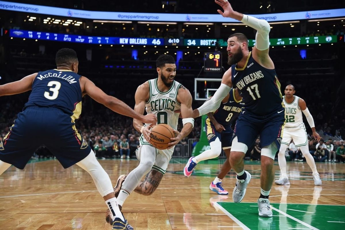 Jan 29, 2024; Boston, Massachusetts, USA;  Boston Celtics forward Jayson Tatum (0) moves to the basket while New Orleans Pelicans guard CJ McCollum (3) and center Jonas Valanciunas (17) defend during the first half at TD Garden.