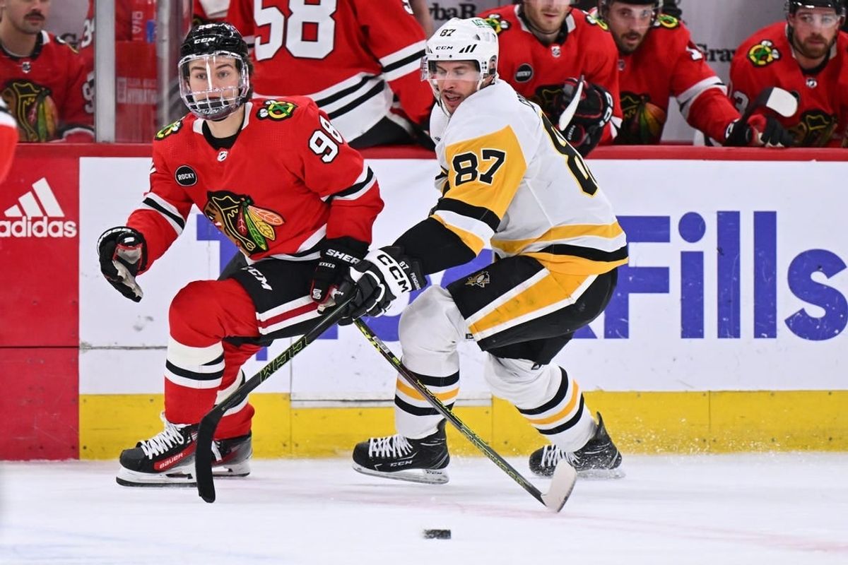 Feb 15, 2024; Chicago, Illinois, USA; Chicago Blackhawks forward Connor Bedard (98) and Pittsburgh Penguins forward Sidney Crosby (87) chase after a loose puck in the first period at United Center.