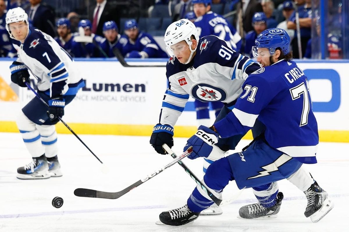 Nov 22, 2023; Tampa, Florida, USA; Winnipeg Jets center Cole Perfetti (91) and Tampa Bay Lightning center Anthony Cirelli (71) fight for the puck during the second period at Amalie Arena.