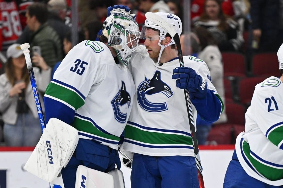 Feb 13, 2024; Chicago, Illinois, USA; Vancouver Canucks goaltender Thatcher Demko (35) and forward Elias Lindholm (23) celebrate after defeating the Chicago Blackhawks 4-2 at United Center.