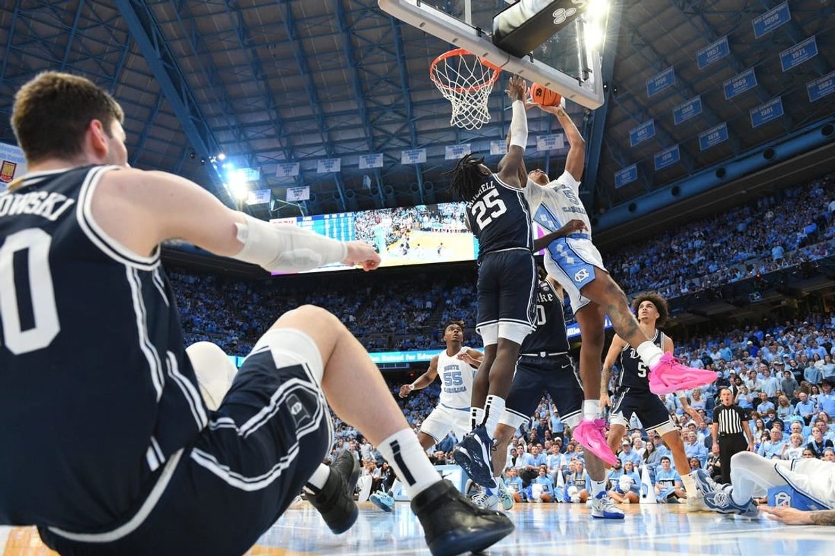 Feb 3, 2024; Chapel Hill, North Carolina, USA; North Carolina Tar Heels forward Armando Bacot (5) shoots as Duke Blue Devils forward Mark Mitchell (25) defends and center Kyle Filipowski (30) sits on the floor in the second half at Dean E. Smith Center.