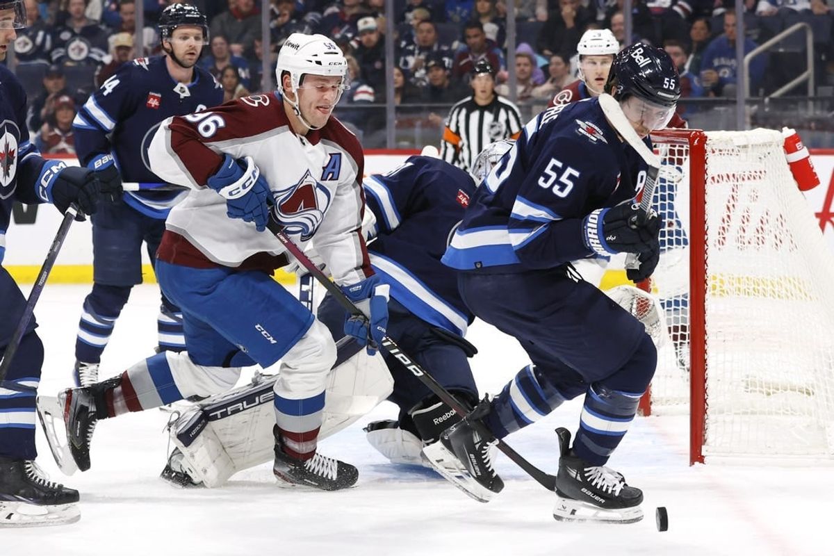 Dec 16, 2023; Winnipeg, Manitoba, CAN; Colorado Avalanche right wing Mikko Rantanen (96) and Winnipeg Jets center Mark Scheifele (55) chase after the puck in the first period at Canada Life Centre.