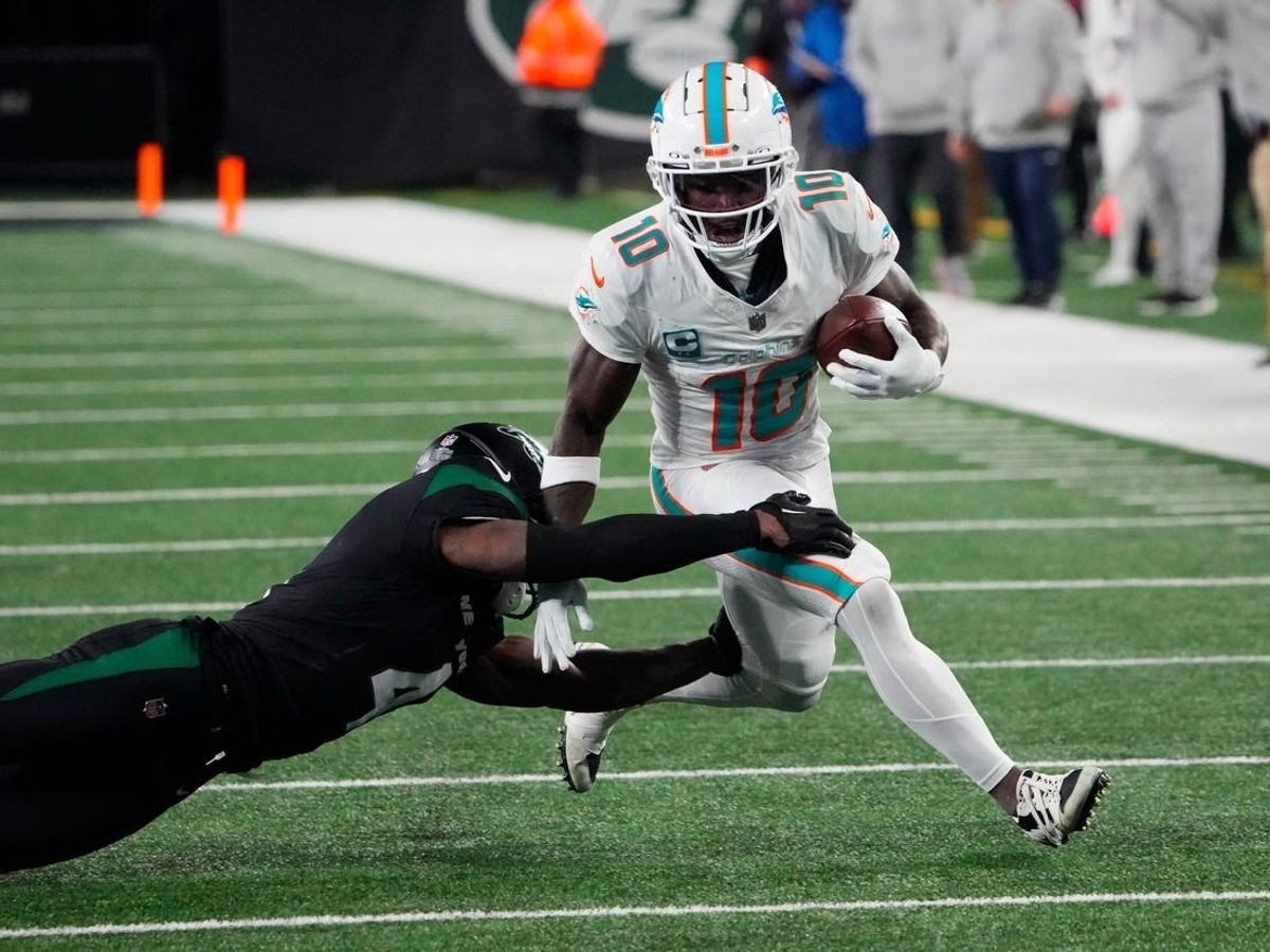 Nov 24, 2023; East Rutherford, New Jersey, USA; Miami Dolphins wide receiver Tyreek Hill (10) is tackled by New York Jets cornerback D.J. Reed (4) in the second half at MetLife Stadium.