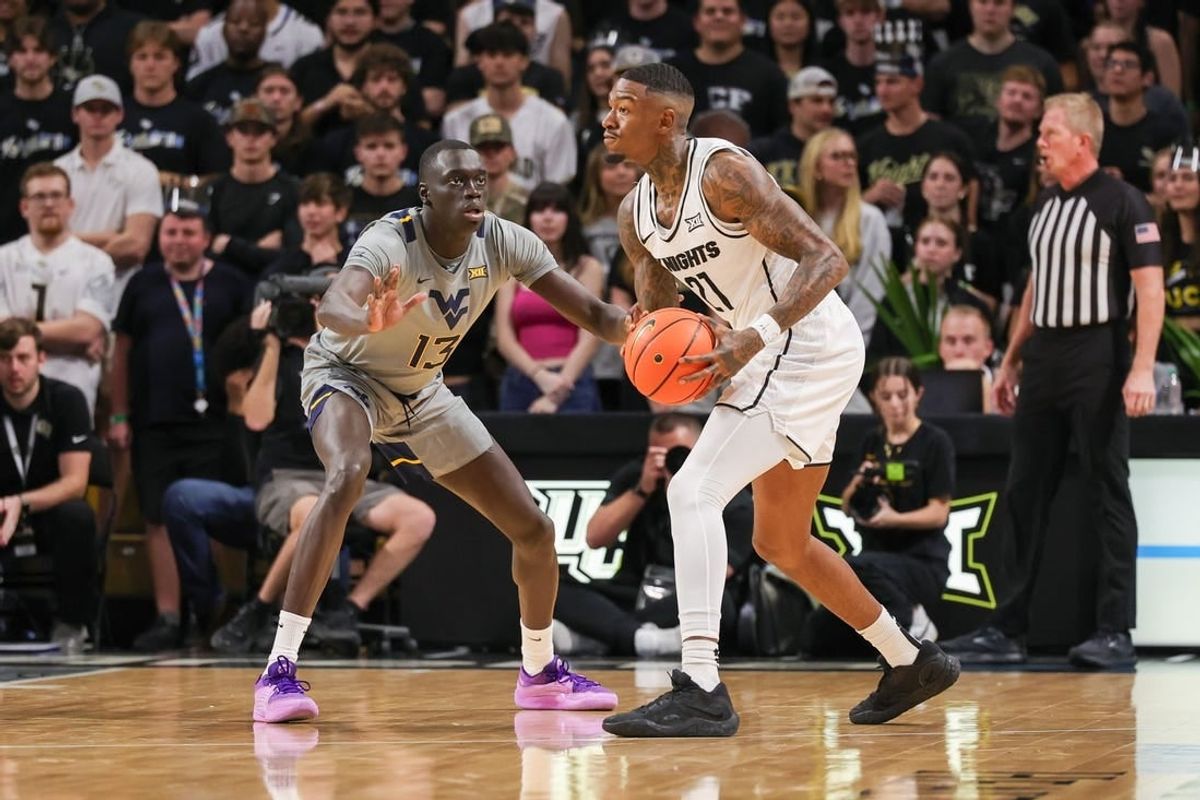 Jan 23, 2024; Orlando, Florida, USA; UCF Knights forward C.J. Walker (21) looks to pass against West Virginia Mountaineers forward Akok Akok (13) during the first half at Addition Financial Arena.
