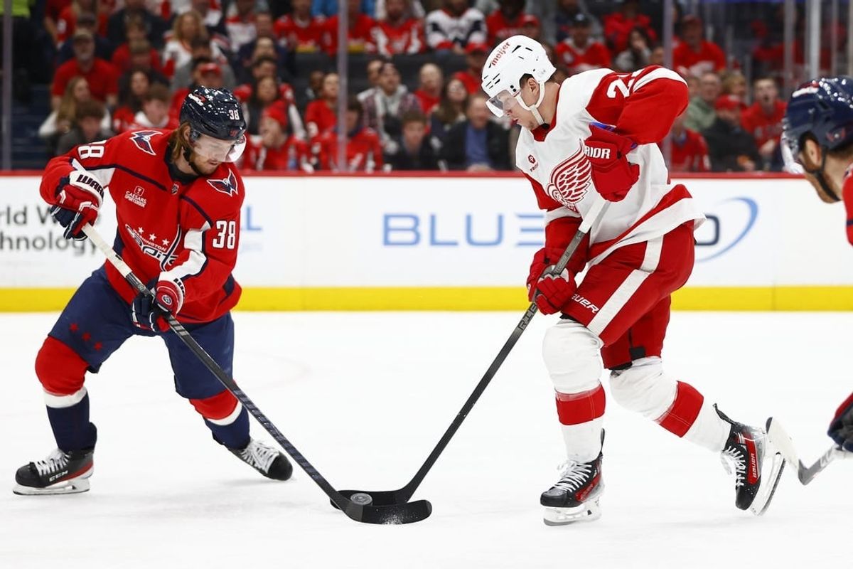 Mar 26, 2024; Washington, District of Columbia, USA; Detroit Red Wings left wing Lucas Raymond (23) battles for the puck with Washington Capitals defenseman Rasmus Sandin (38) during the second period at Capital One Arena.