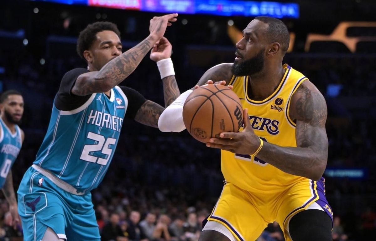 Dec 28, 2023; Los Angeles, California, USA;  Charlotte Hornets forward P.J. Washington (25) defends Los Angeles Lakers forward LeBron James (23) in the first half at Crypto.com Arena.