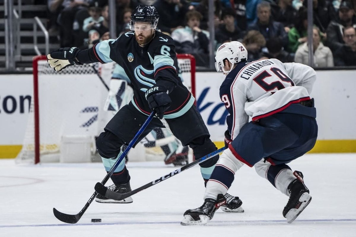 Jan 28, 2024; Seattle, Washington, USA; Seattle Kraken defenseman Adam Larsson (6) attempts to knock the puck away from Columbus Blue Jackets forward Yegor Chinakhov (59) during the second period at Climate Pledge Arena.