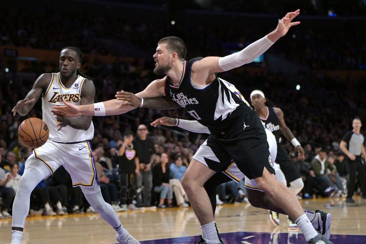Jan 7, 2024; Los Angeles, California, USA;   Los Angeles Lakers forward Taurean Prince (12) and Los Angeles Clippers center Ivica Zubac (40) reach for a rebound in the second half at Crypto.com Arena.