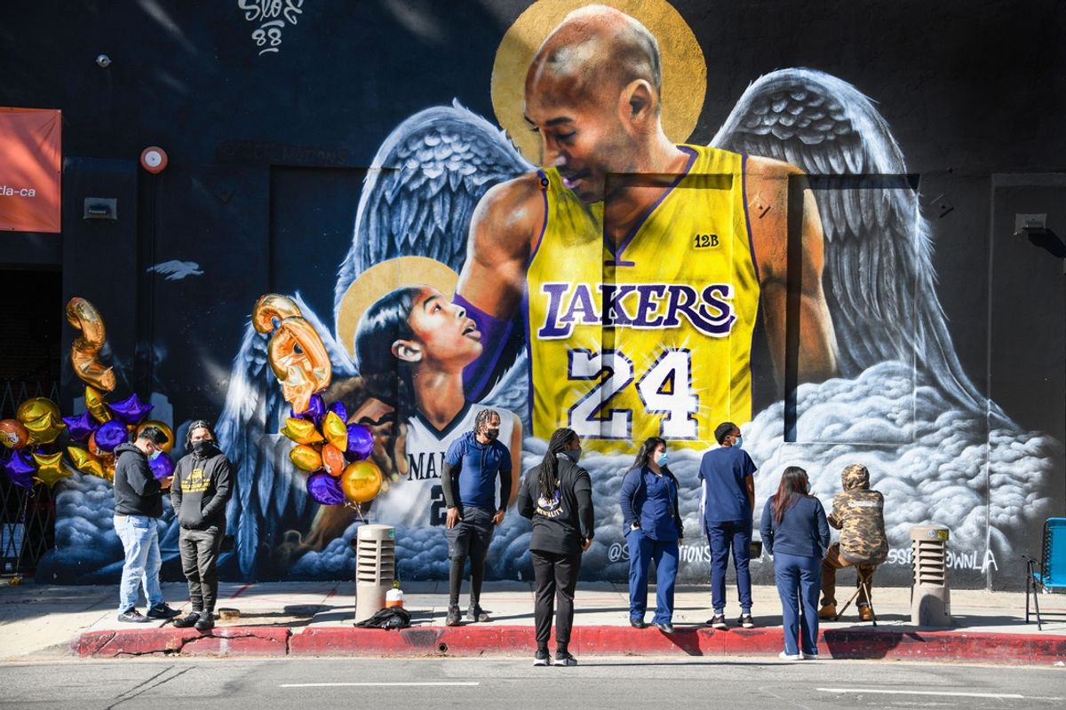 Jan 26, 2021; Los Angeles, California, USA; Fans gather at a mural of Kobe Bryant and his daughter Gianna painted on the wall of Hardcore Fitness Bootcamp gym in downtown Los Angeles. Bryant and his daughter and seven other persons died in a helicopter crash in Calabasas, Calif. on Jan. 26, 2020. Mandatory Credit: Robert Hanashiro-Imagn Images