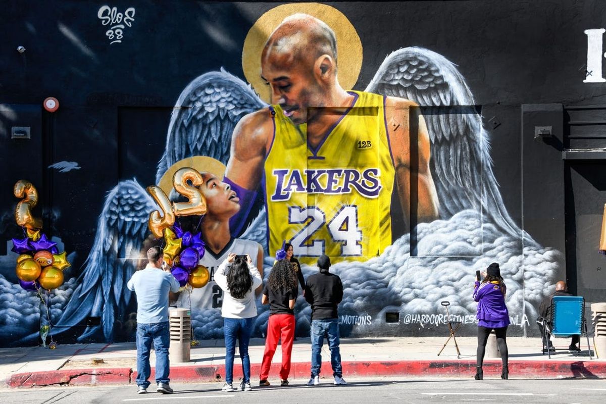 Jan 26, 2021; Los Angeles, California, USA; Fans gather at a mural of Kobe Bryant and his daughter Gianna painted on the wall of Hardcore Fitness Bootcamp gym in downtown Los Angeles. Bryant and his daughter and seven other persons died in a helicopter crash in Calabasas, Calif. on Jan. 26, 2020. Mandatory Credit: Robert Hanashiro-USA TODAY Sports