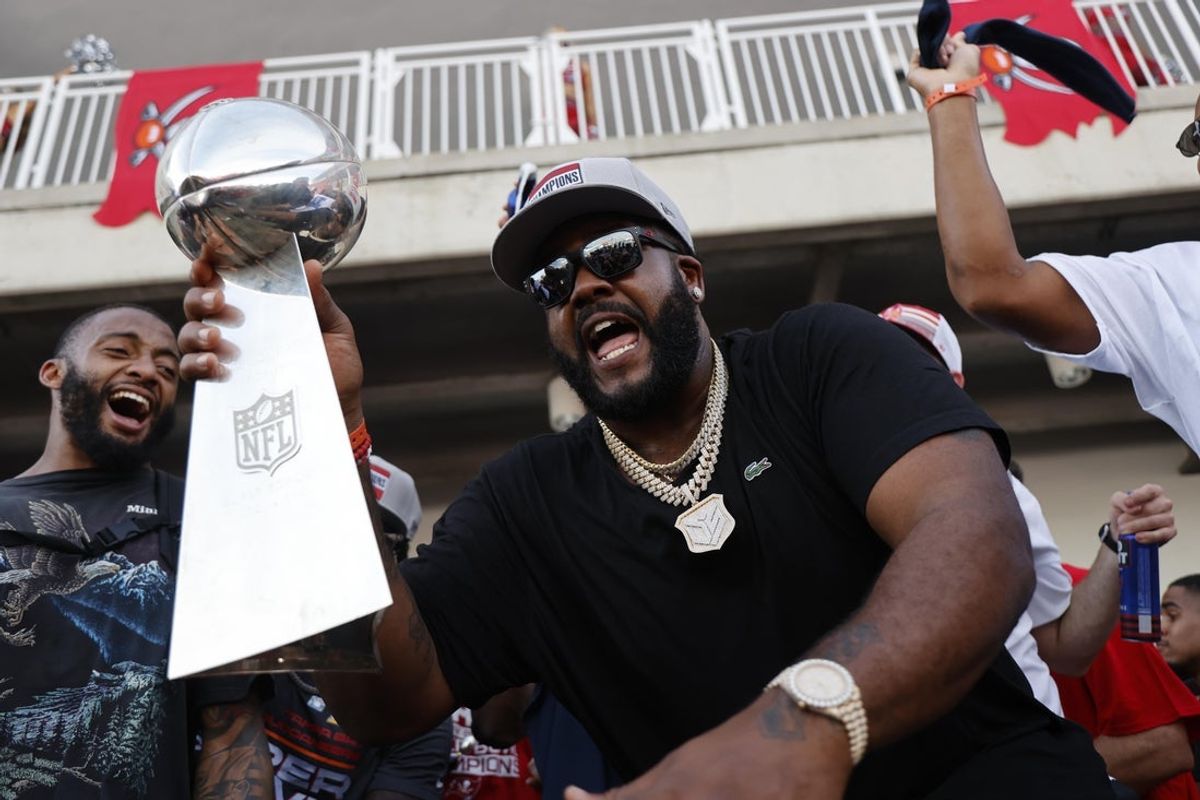 Feb 10, 2021; Tampa Bay, FL, USA;  Tampa Bay Buccaneers offensive tackle Donovan Smith dances with the Vince Lombardi Trophy during a boat parade to celebrate victory in Super Bowl LV against the Kansas City Chiefs. Mandatory Credit: Kim Klement-Imagn Images