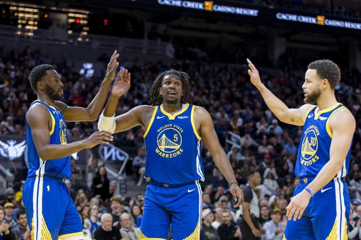 Jan 4, 2024; San Francisco, California, USA; Golden State Warriors forward Andrew Wiggins (22) and guard Kevon Looney (5) and guard Stephen Curry (30) react after drawing a foul against the Denver Nuggets during the first half at Chase Center.