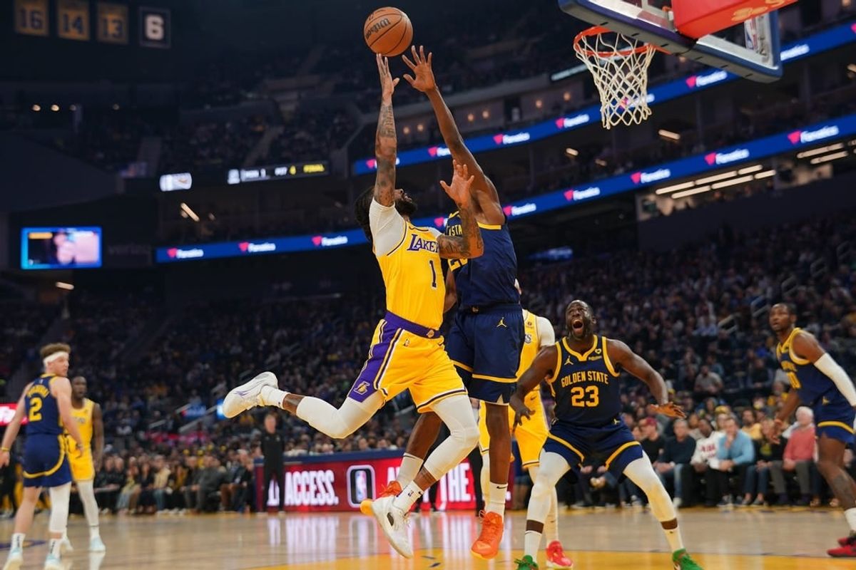 Feb 22, 2024; San Francisco, California, USA; Los Angeles Lakers guard D'Angelo Russell (1) makes a basket over Golden State Warriors forward Andrew Wiggins (22) in the first quarter at the Chase Center.