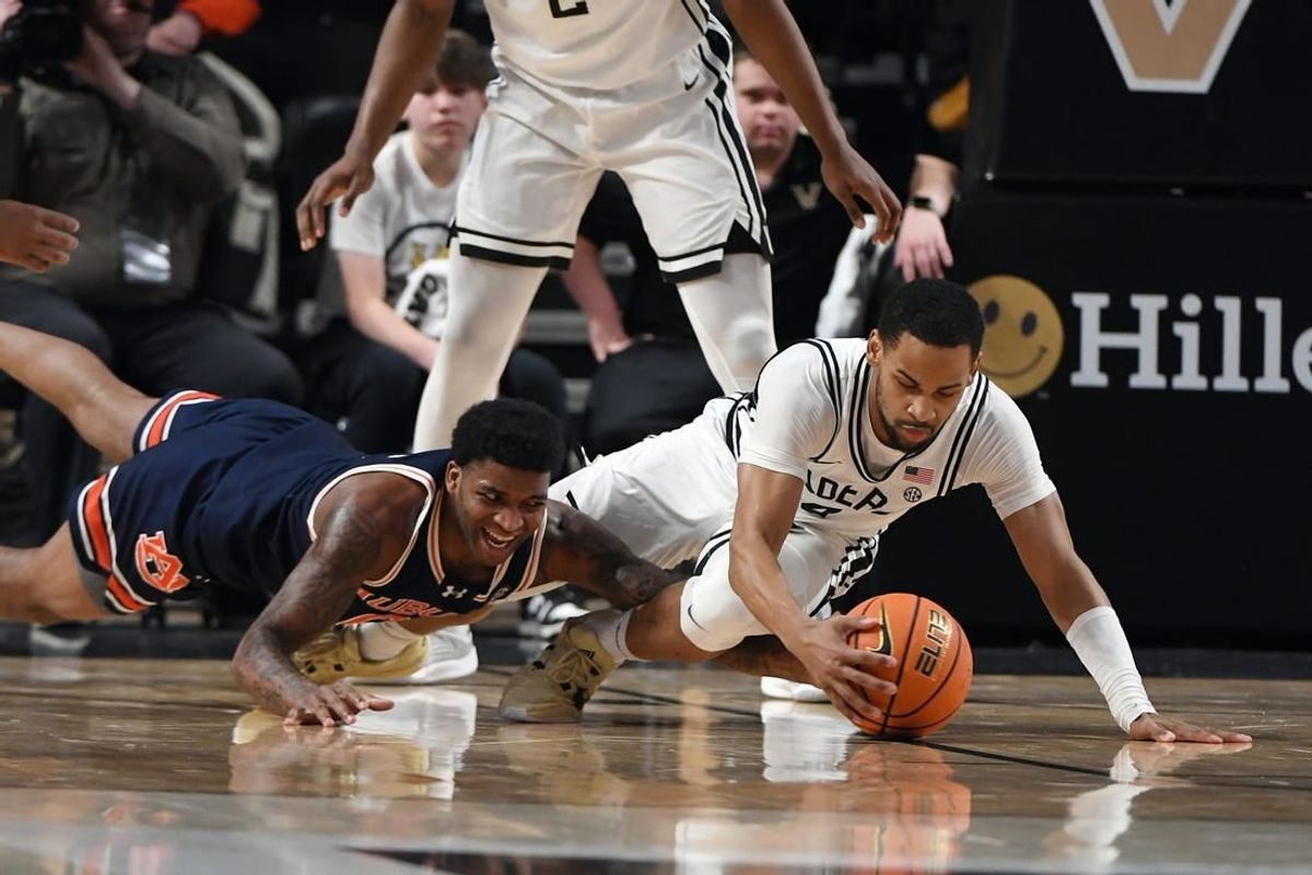 Jan 17, 2024; Nashville, Tennessee, USA; Auburn Tigers guard K.D. Johnson (0) and Vanderbilt Commodores guard Isaiah West (4) dive for a loose ball during the first half at Memorial Gymnasium.