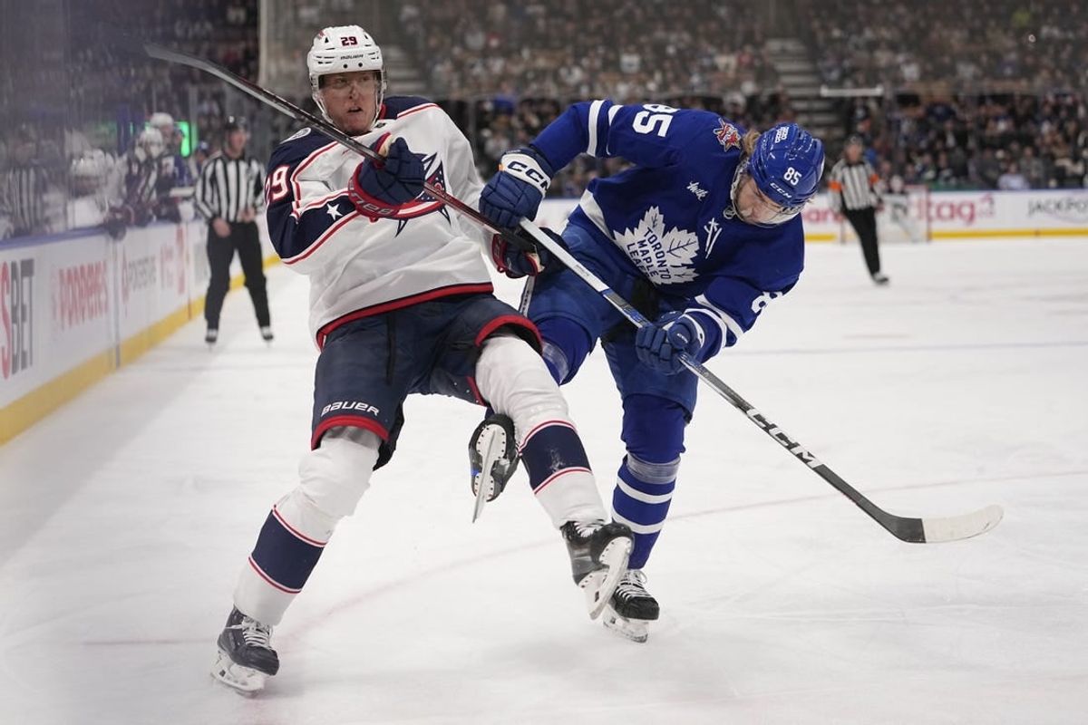 Dec 14, 2023; Toronto, Ontario, CAN; Toronto Maple Leafs defenseman William Lagesson (85) upends Columbus Blue Jackets forward Patrik Laine (29) as they go to the boards during the second period at Scotiabank Arena.