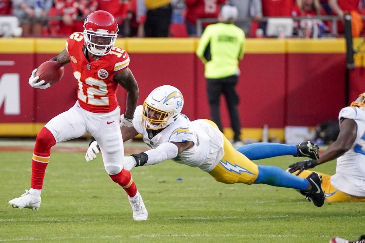 Oct 12, 2023; Kansas City, Missouri, USA; Kansas City Chiefs wide receiver Mecole Hardman Jr. (12) returns a kick as Los Angeles Chargers linebacker Chris Rumph II (94) attempts the tackle during the game at GEHA Field at Arrowhead Stadium.