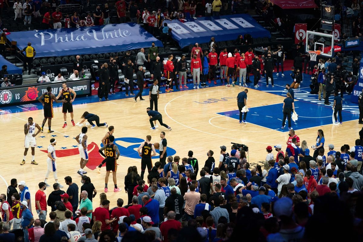 Jun 20, 2021; Philadelphia, Pennsylvania, USA; Arena staff cleans up the court after objects are thrown onto the court during the fourth quarter in game seven of the second round of the 2021 NBA Playoffs between the Philadelphia 76ers and Atlanta Hawks at Wells Fargo Center. Mandatory Credit: Bill Streicher-USA TODAY Sports