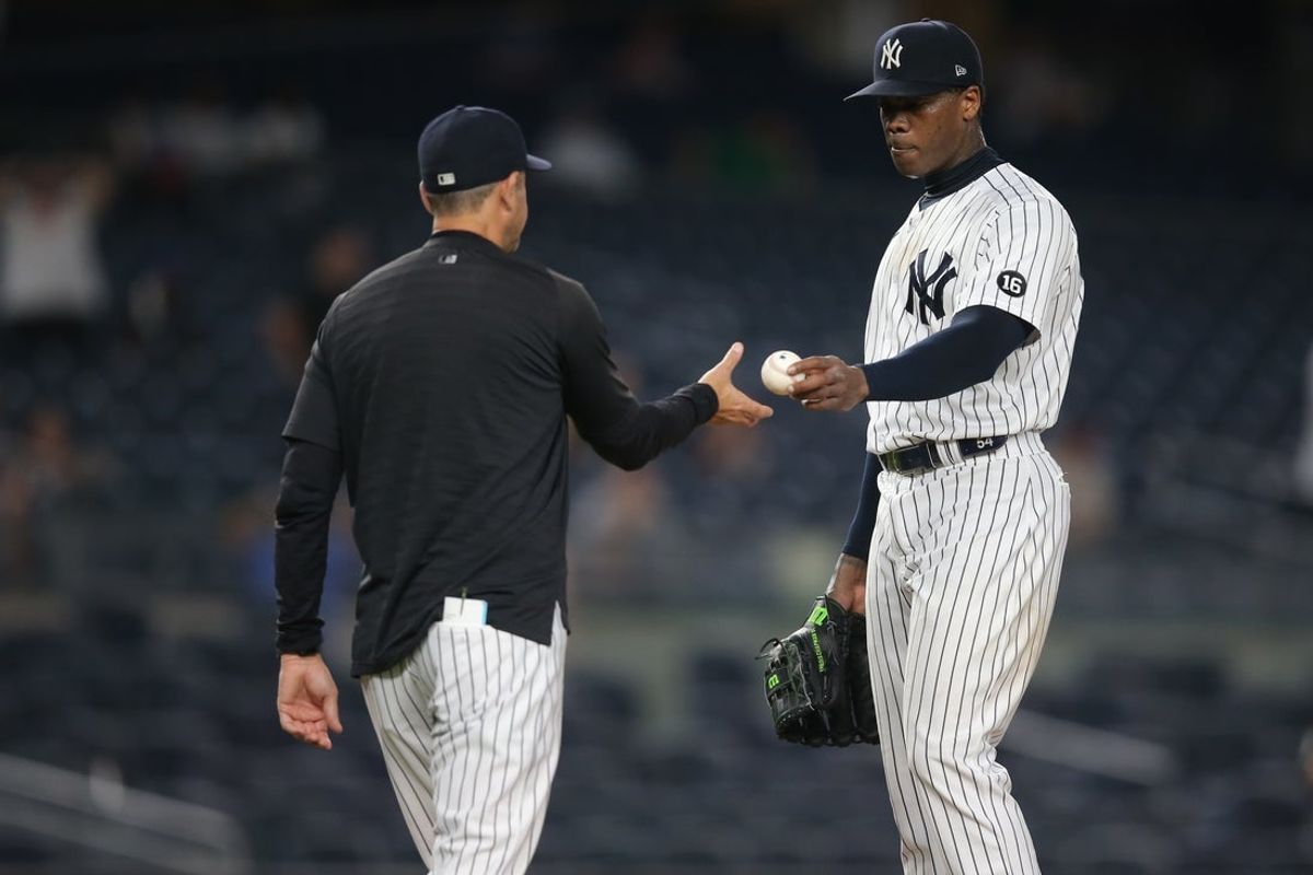 Jun 30, 2021; Bronx, New York, USA; New York Yankees manager Aaron Boone (left) takes relief pitcher Aroldis Chapman (right) out of the game against the Los Angeles Angels during the ninth inning at Yankee Stadium. Mandatory Credit: Brad Penner-Imagn Images